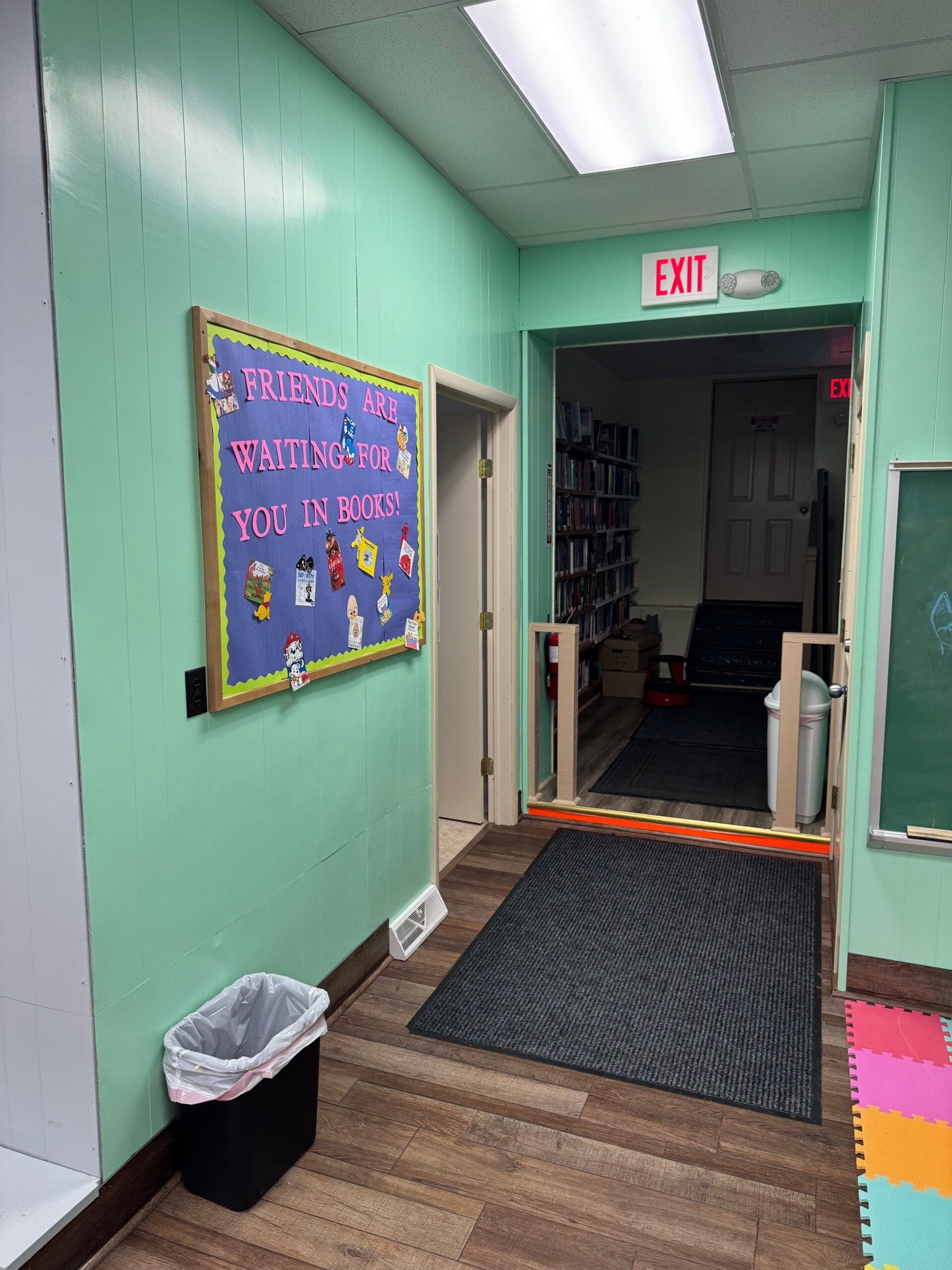 Library Photo of the bathroom, bulletin board, emergency exit, and stairway access.